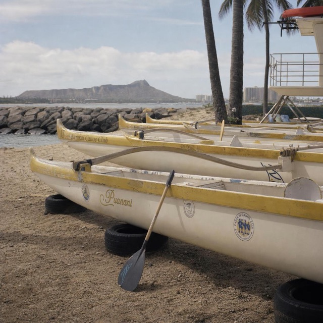 Outrigger canoes resting beside a Honolulu breakwater at sunrise
